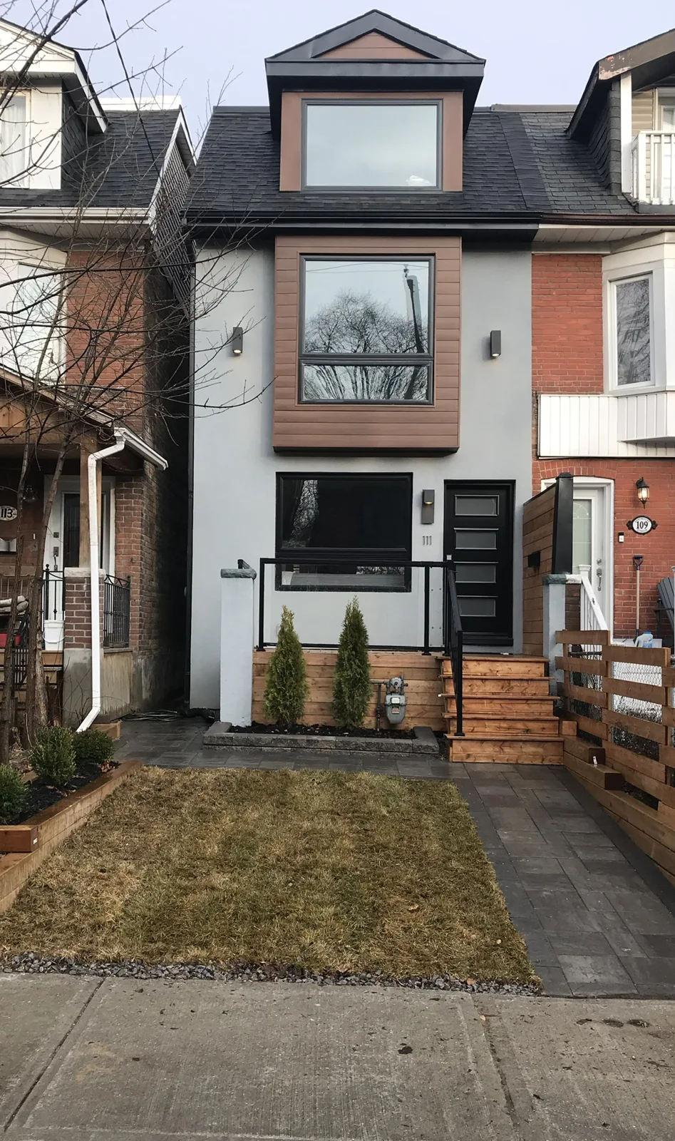 Completed townhouse facade with dark cladding and new entry
