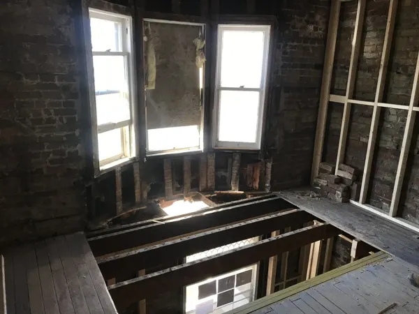 Front room with exposed floor joists and bay window