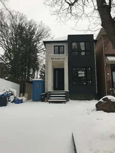 Front exterior — facade complete while site work continues