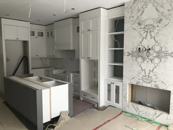 Kitchen — island cabinetry and stone fireplace surround