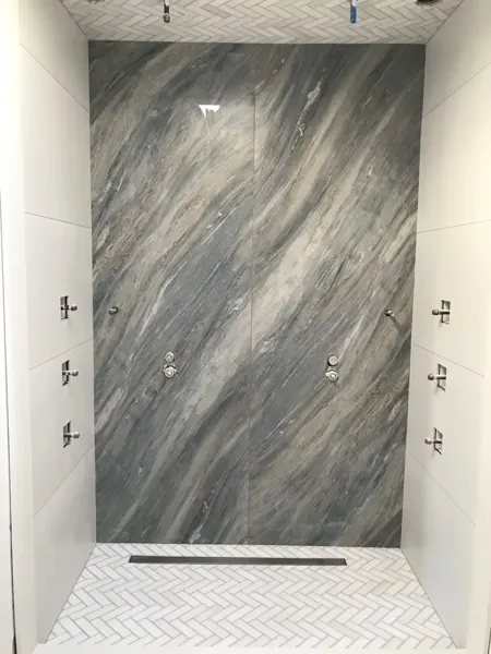 Shower — stone slab and herringbone tile installation