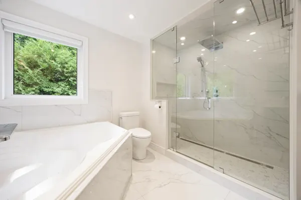 Completed bathroom with freestanding bath and glass shower