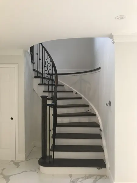 Dark stair treads and metal railing installed; lighting still in progress