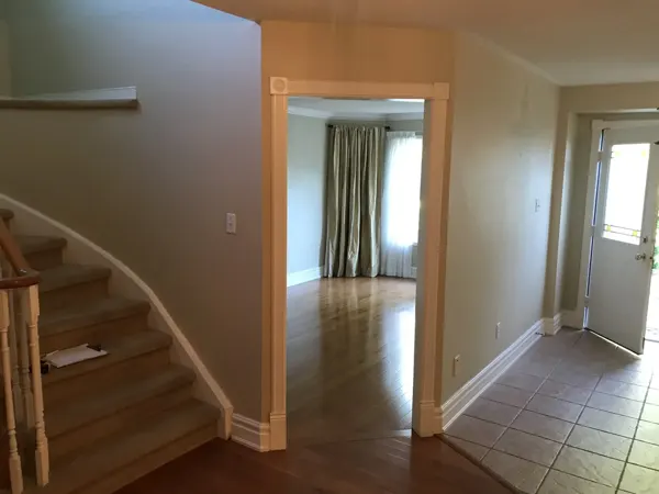 Existing foyer, staircase and adjoining room
