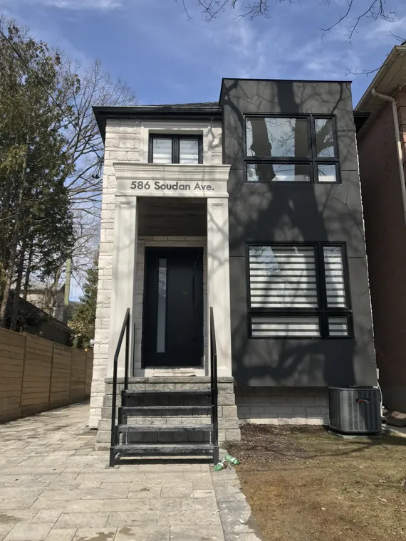 Completed front exterior — stone entrance and dark bay