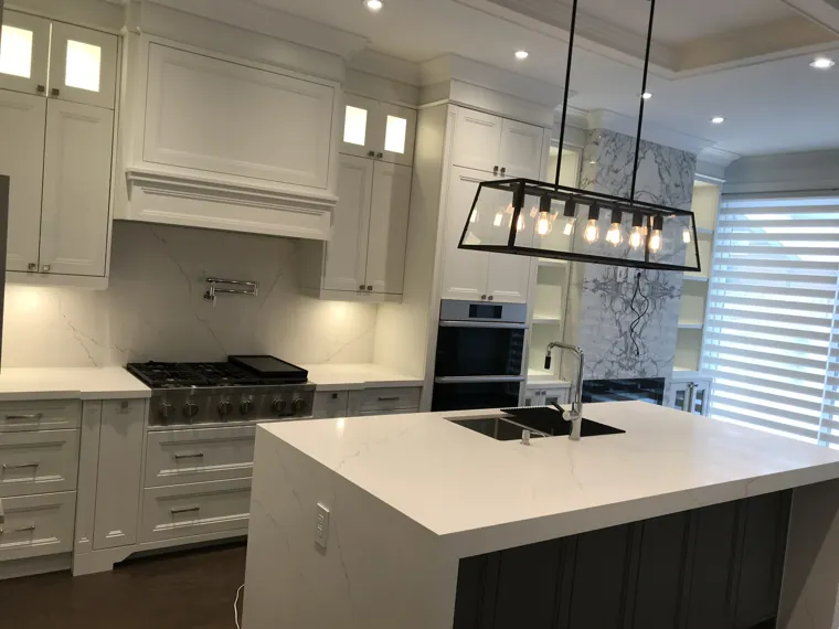 Completed kitchen — cooktop, island and fireplace wall