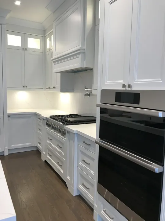 Completed kitchen — ovens, cooktop and tall cabinetry