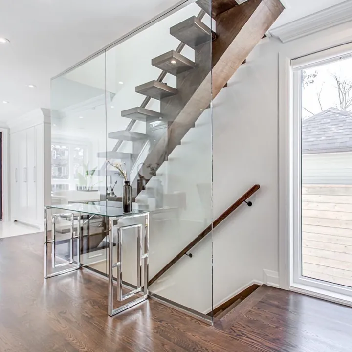 Completed staircase — glass balustrade and open timber treads